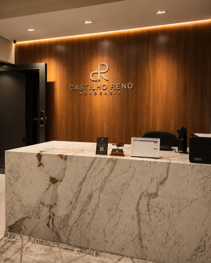 Recepção do escritório, com painel de madeira e o letreiro do Castilho Renó Advocacia